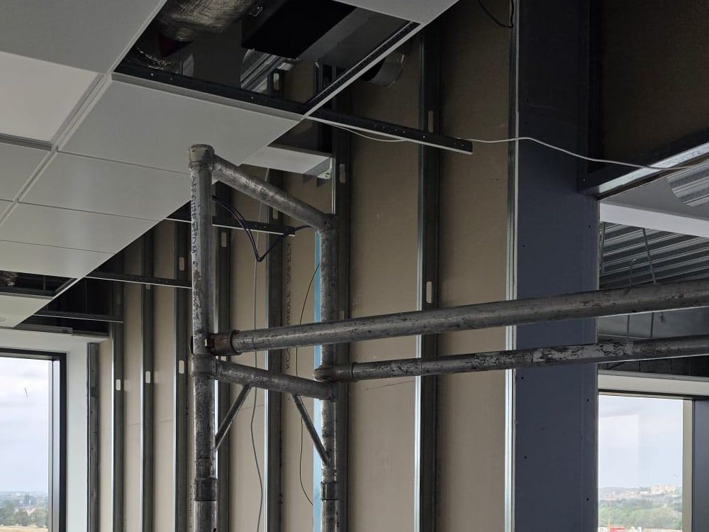 Metal studs fixed between floor and ceiling track in an office being fitted out